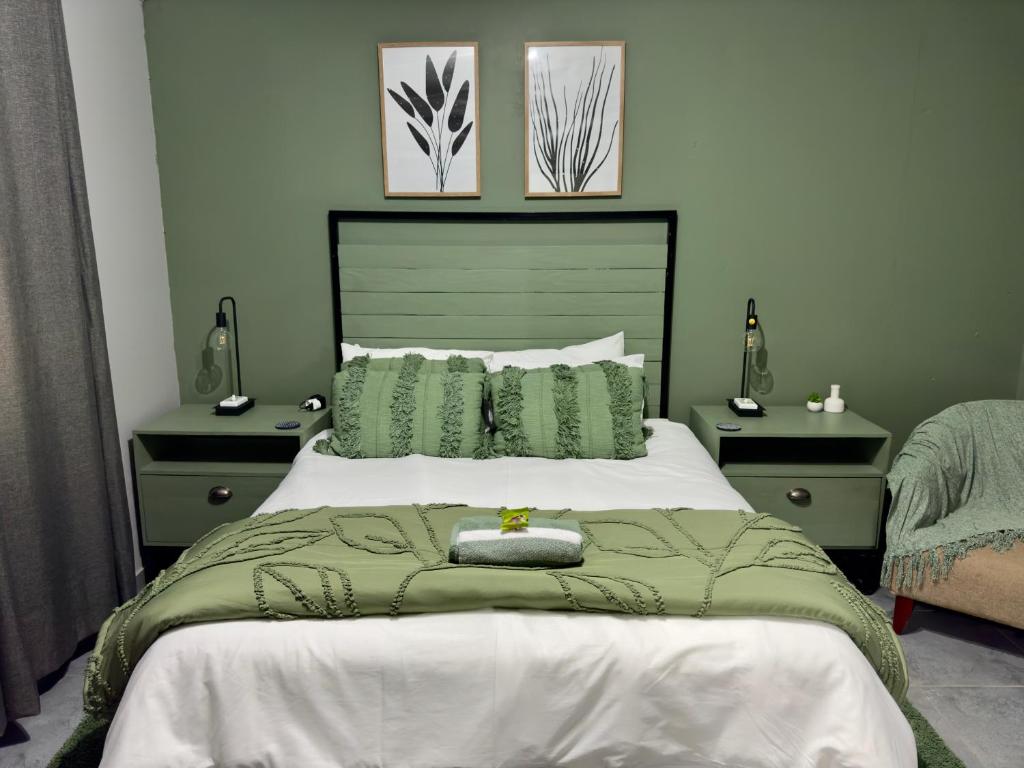 a bedroom with a green and white bed with two night stands at Wild Fig Rest Guest House in Polokwane