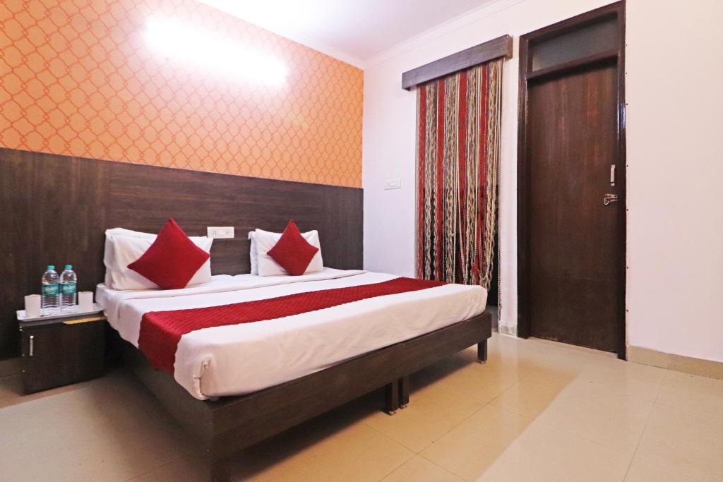 a bedroom with a large bed with red pillows at Hotel The Nines - Dashrathpuri Metro in New Delhi