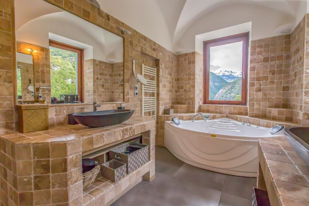 a bathroom with a large tub and a sink at Domaine au cœur des 3 vallées in Moutiers