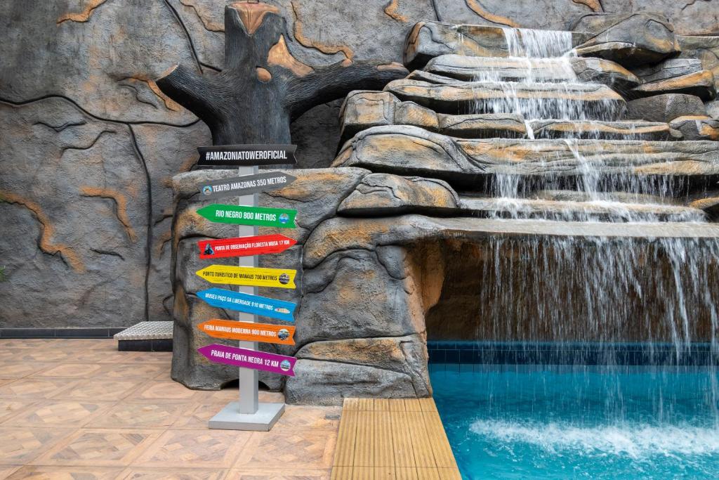 a directional sign in front of a waterfall at Rede Andrade Amazônia in Manaus