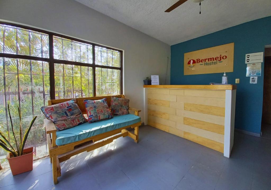 una sala de espera con un banco y una ventana grande en Bermejo Hostel, en La Paz