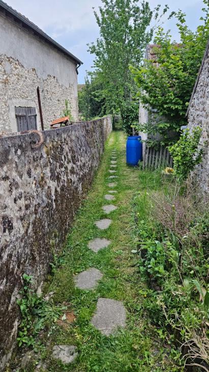 an alley with a stone wall next to a building at Saint Quentin en Yvelines- Montigny le Bretonneux village, avec jardin,10min des sites olympiques de golf et de vélo, 15 minutes de Versailles 30 minutes de Paris Host fluent in English in Montigny-le-Bretonneux