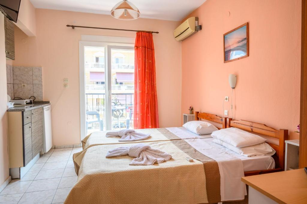 two beds in a room with a window at Sunrise2 in Paralia Katerinis