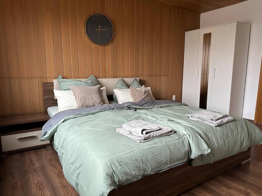 a bedroom with a large bed with a clock on the wall at Ferienwohnung Malin in Ludwigshafen am Rhein