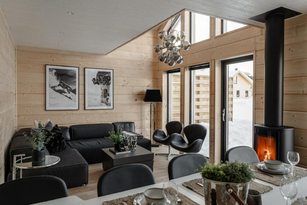 sala de estar con sofá y chimenea en Helt nytt exklusivt boende i Stöten, en Sälen