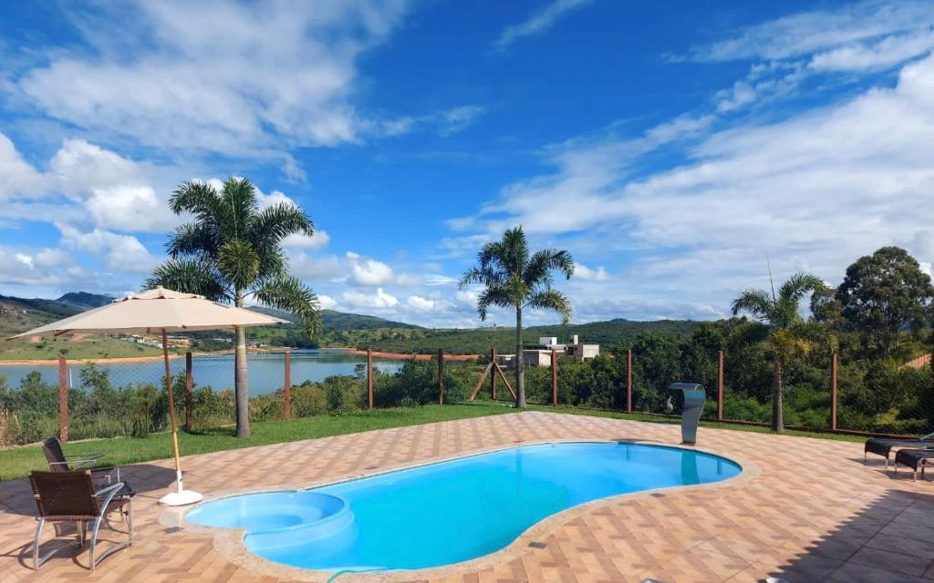 a swimming pool with a view of a lake at Rancho Paraíso in Capitólio