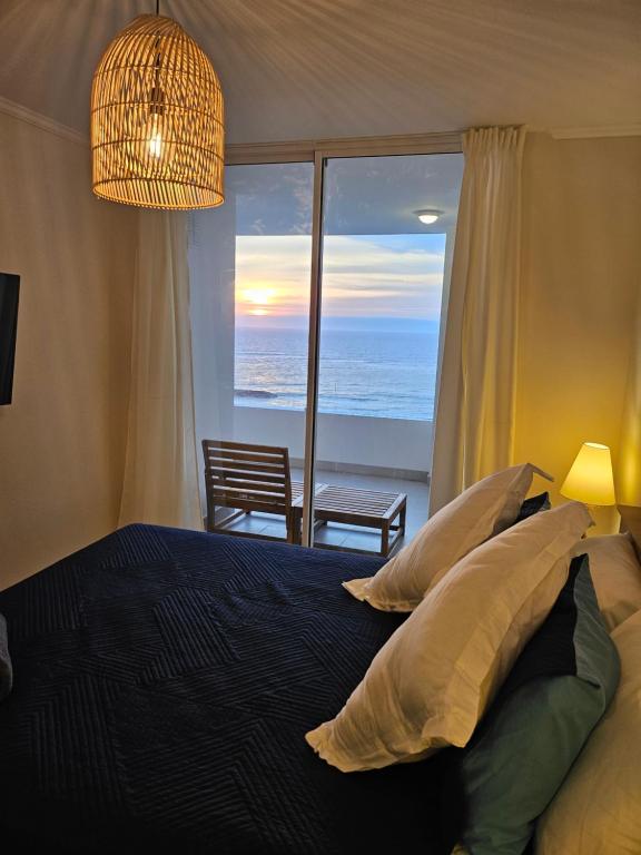 a bedroom with a bed with a view of the ocean at Departamento con espectacular vista al mar Arica, Condominio Ayllu in Arica