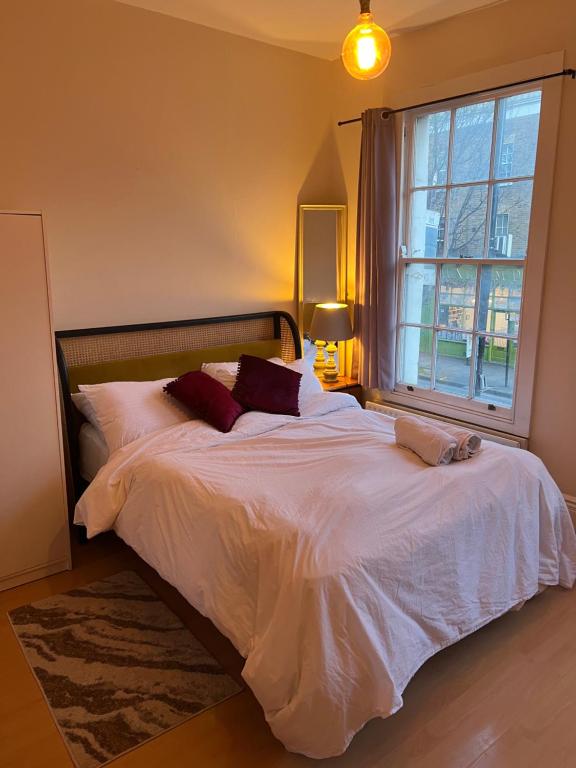 a bedroom with a large white bed with a window at Apartament Kings Cross in London