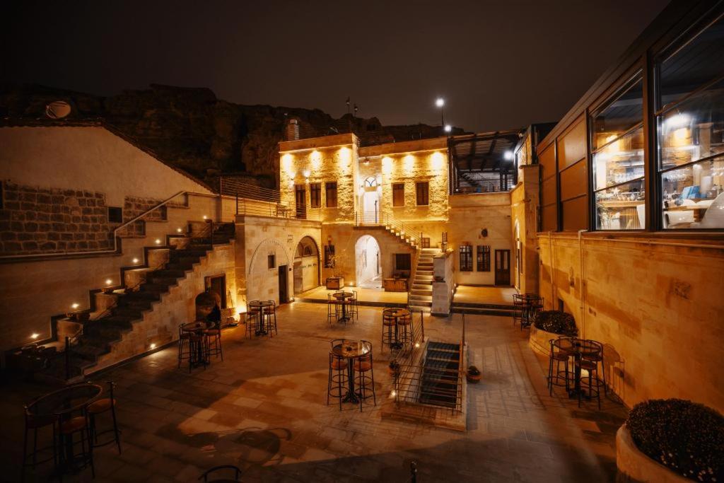 a building with chairs and tables in a courtyard at night at Misty Cave Hotel in Ürgüp