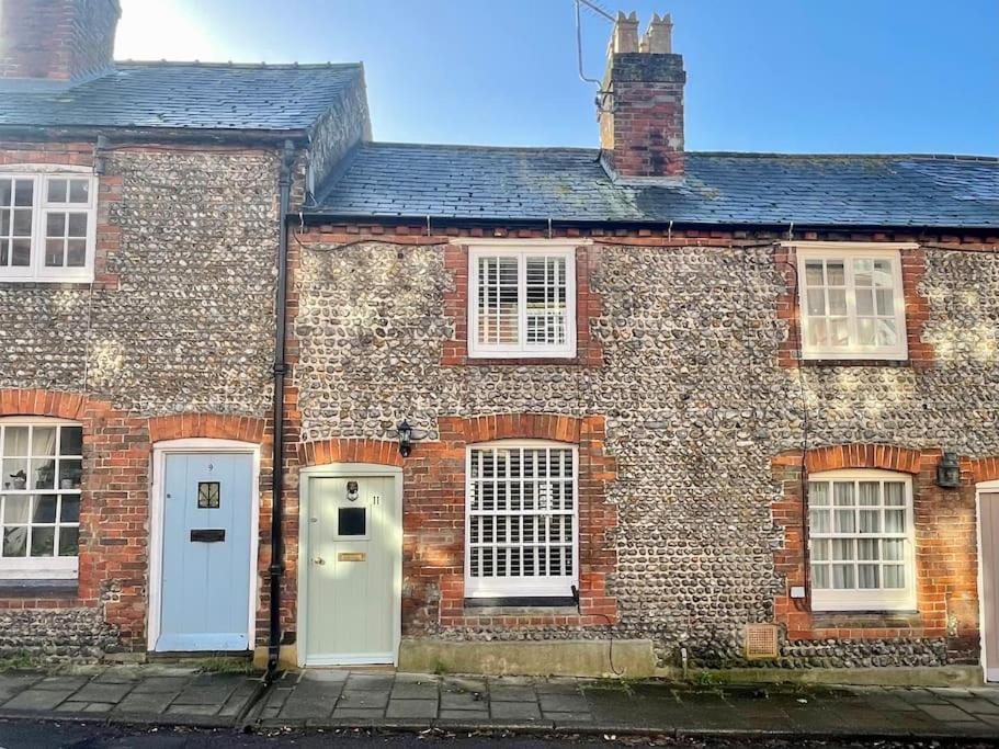 an old brick house with white doors and windows at Quaint Cottage in the heart of Arundel in Arundel