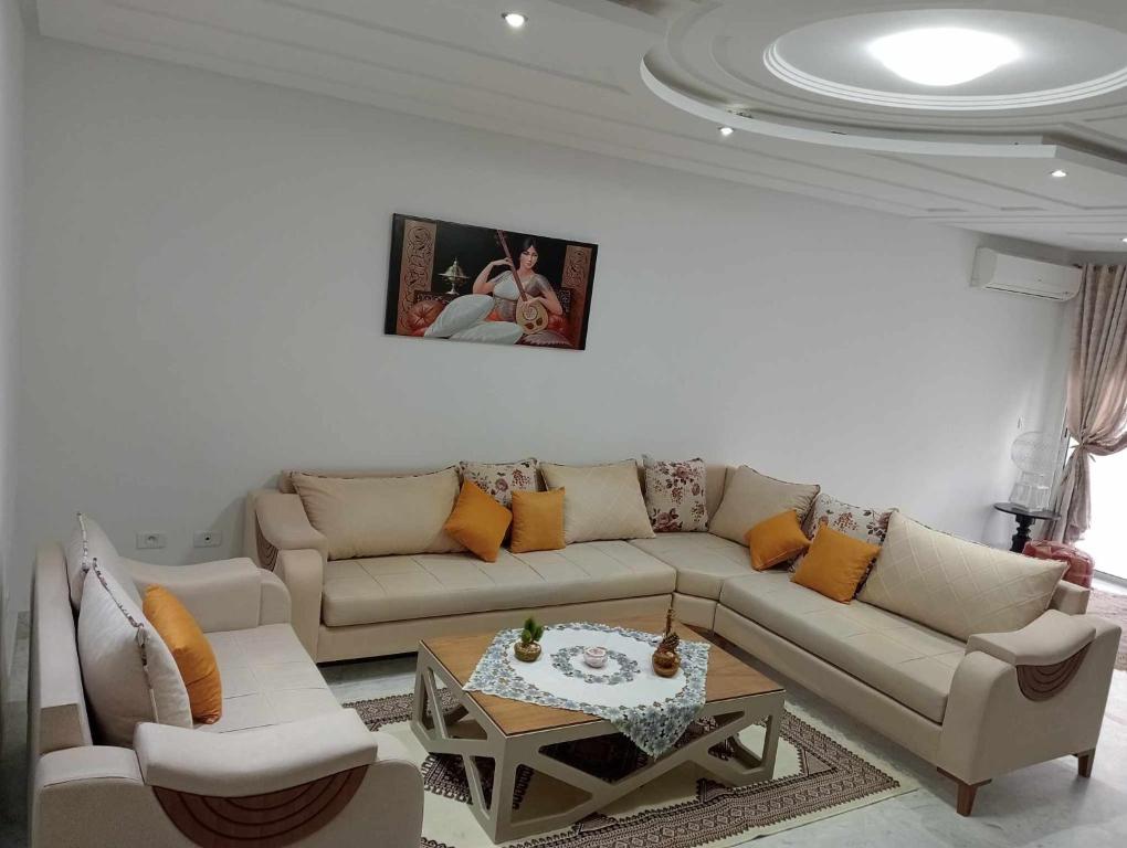 sala de estar con sofá y mesa en appartement S+2, proche plage en Monastir