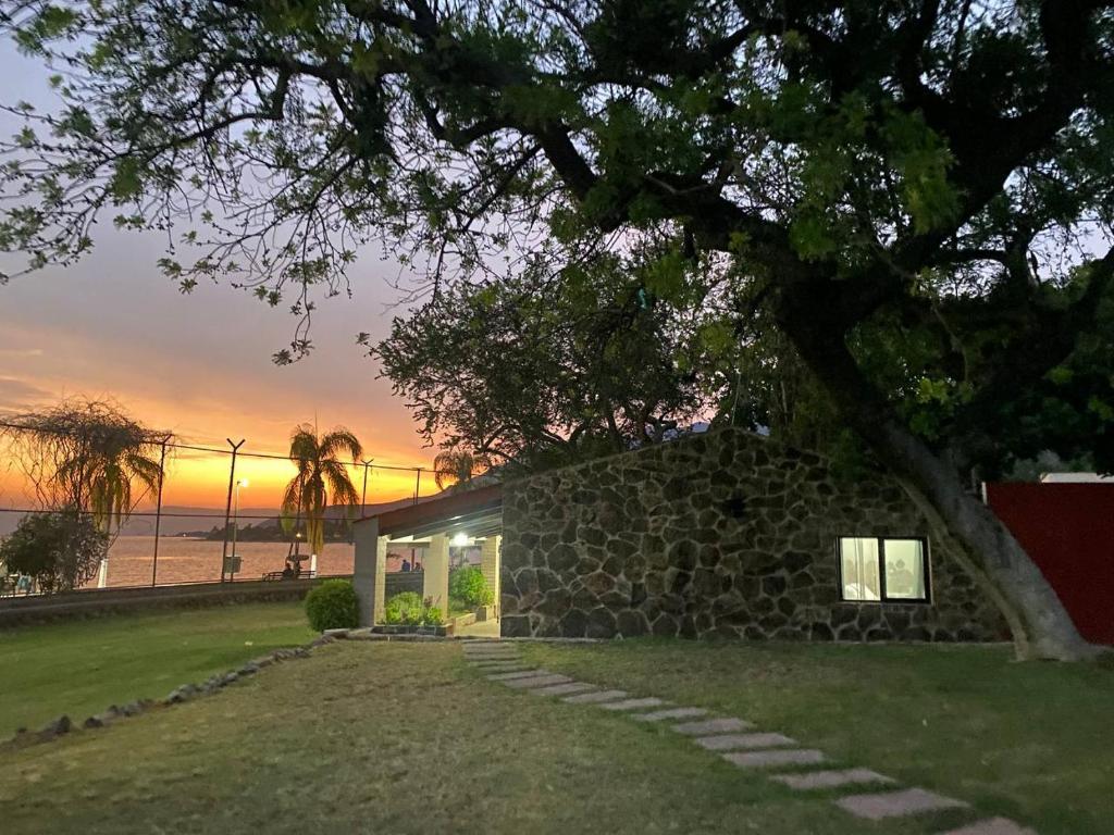 uma casa de pedra com uma árvore e uma parede de pedra em Cabaña del Lago em Ajijic