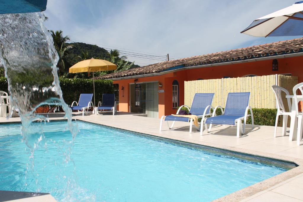 a swimming pool with a water fountain at Pousada Porto Paraiso, o seu Paraíso Escondido no Guarujá in Guarujá