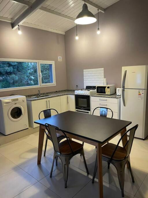 eine Küche mit Tisch und Stühlen und einem Kühlschrank in der Unterkunft Hygge Loft Patagonia in Dina Huapi