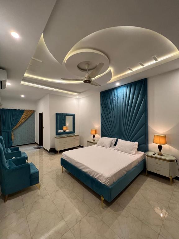 a bedroom with a large bed and a blue chair at The Gateway islamabad in Islamabad