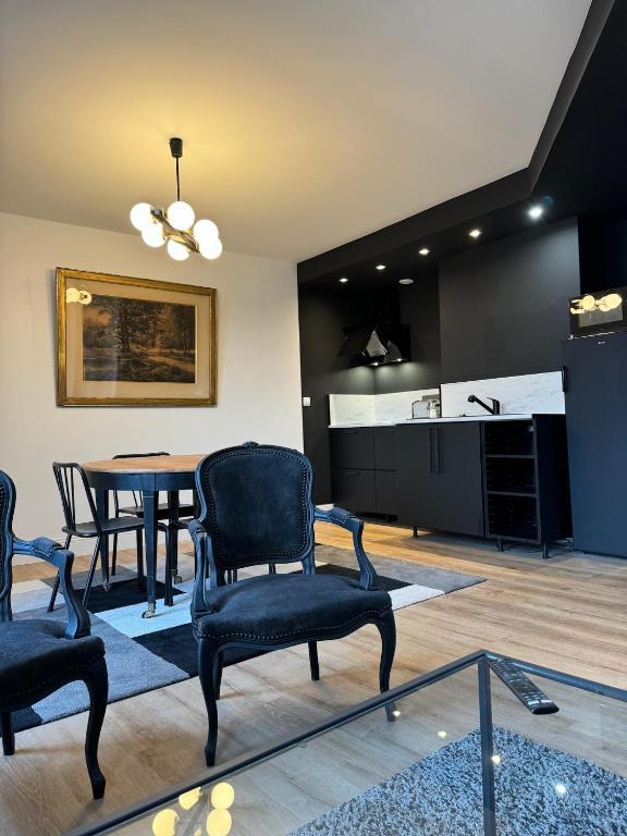 un salon avec une table et des chaises et une cuisine dans l'établissement Le 28 - Résidence de Standing en Vieille-ville avec Parking, à Boulogne-sur-Mer