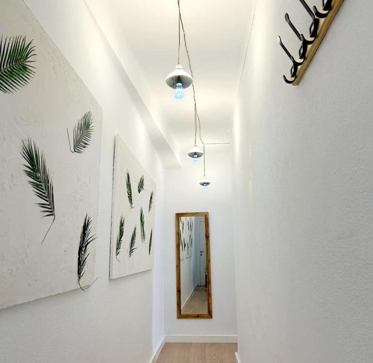 een hal met schilderijen aan de muur en een spiegel bij Maravilloso apartamento en el centro in Ceuta