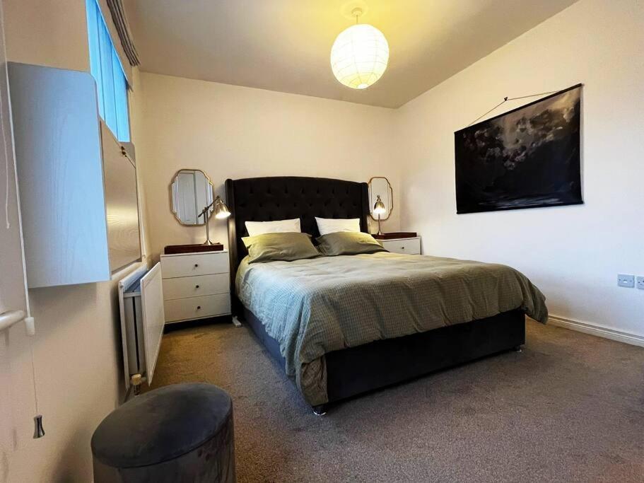 um quarto com uma cama grande e uma cadeira em Snug House - Dromore Village - Lagan River View em Dromore