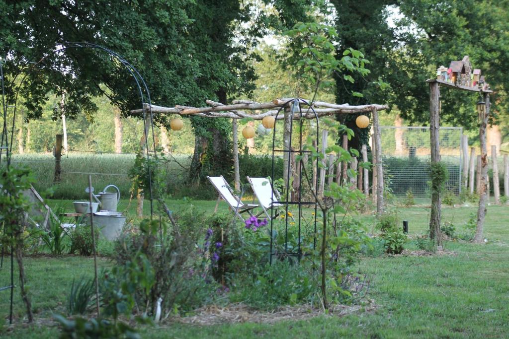 een tuin met een pergola in het gras bij Manoir de l'Alleu in La Chapelle-Chaussée