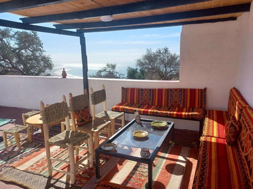 een woonkamer met een bank en een tafel bij Superbe appartement , grande terrasse vue mer et montagne Taghazout in Taghazout