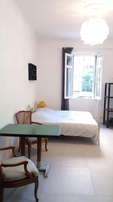 une chambre avec un lit, une table et une chaise dans l'établissement Grand studio de 30m2 !central !spacieux !différent !, à Cannes