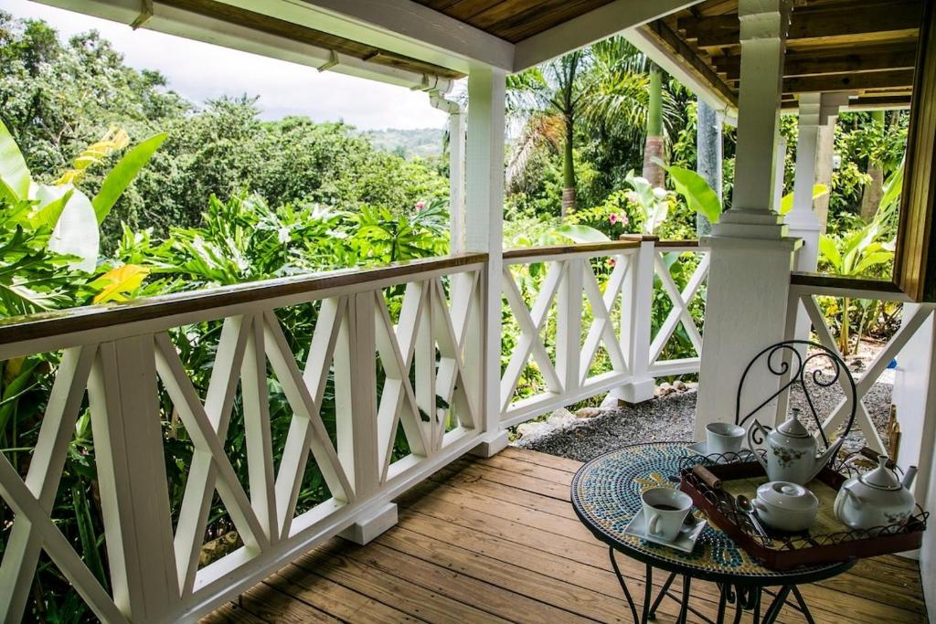 a porch with a table and chairs on it at Monte Sagrado Reserve-100 acres Wellness River cabin in Quebrada