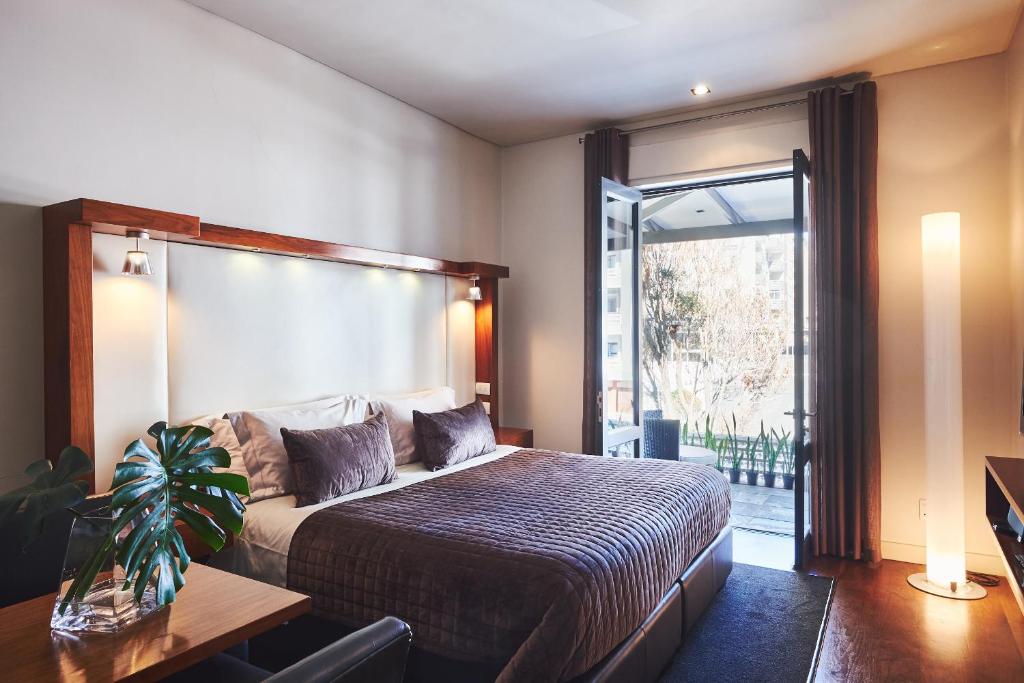 sypialnia z łóżkiem i dużym oknem w obiekcie Hotel on the Promenade w Kapsztadzie
