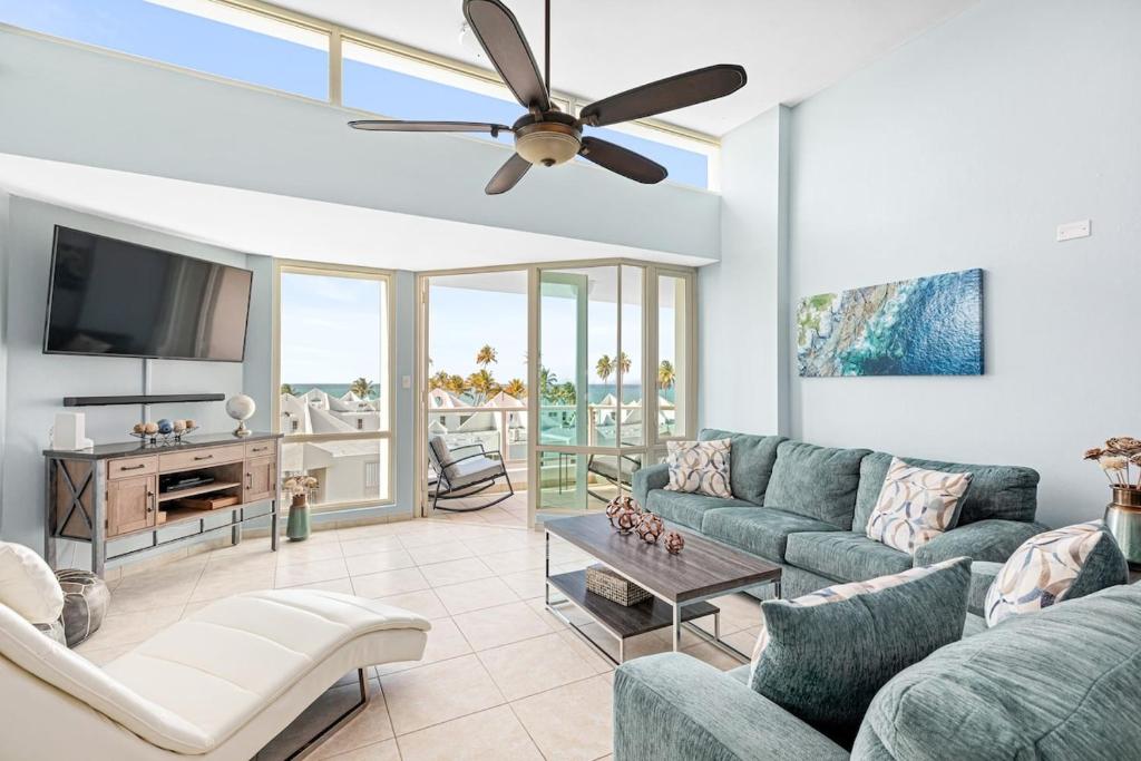 uma sala de estar com um sofá e uma ventoinha de tecto em Ocean View Penthouse with pool, beachfront complex apts em Río Grande