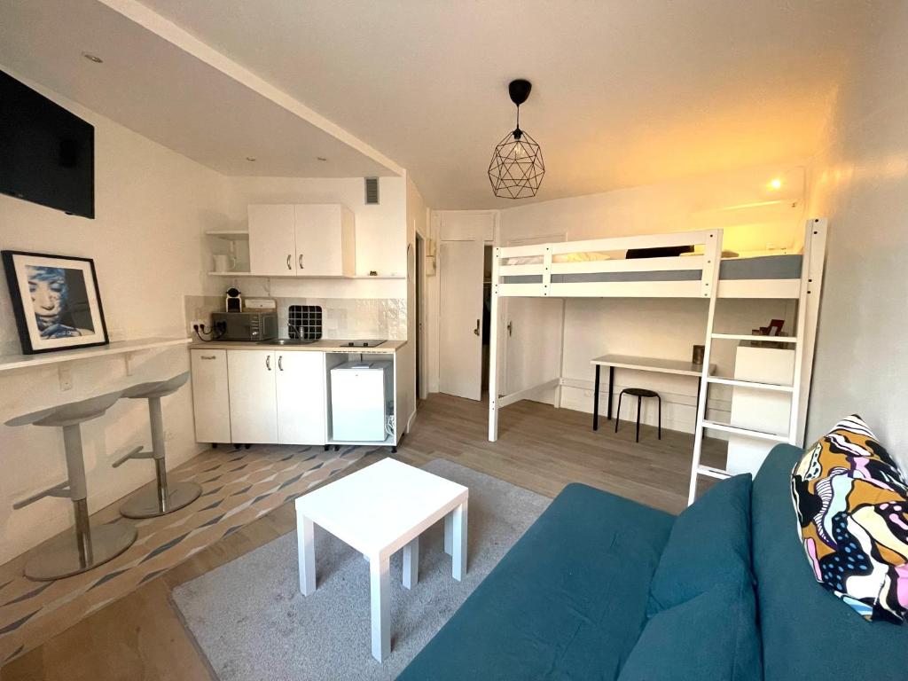 un salon avec un canapé bleu et une cuisine dans l'établissement Dans le triangle d’Or de Boulogne, à Boulogne-Billancourt