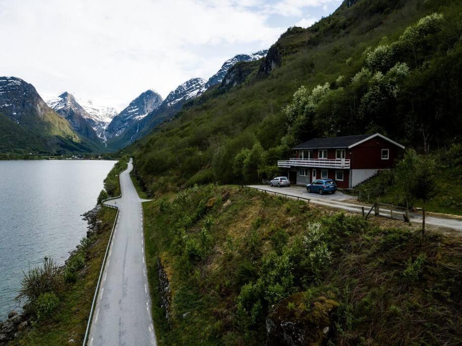 a house on the side of a road next to a lake at Lake View Apartment, Oldedalen in Stryn