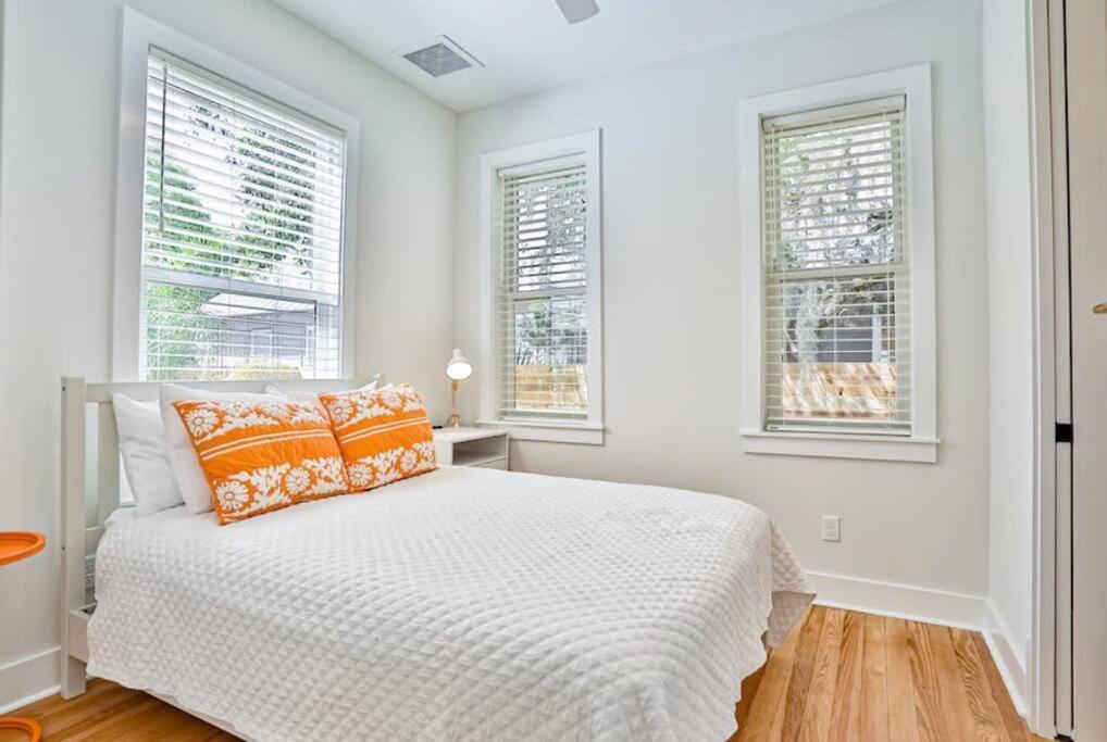 a white bedroom with a bed and two windows at Downtown Historic Charmer in Saint Augustine