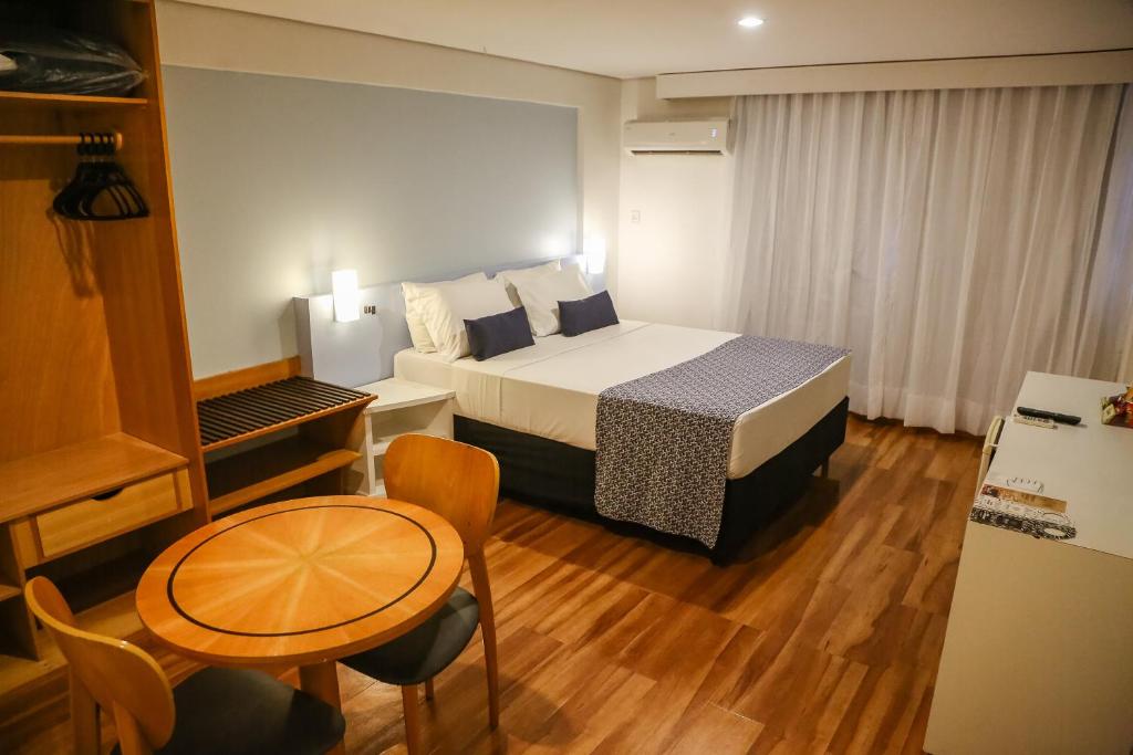 um quarto de hotel com uma cama e uma mesa e uma cozinha em Bristol Jangada Fortaleza Meirelles em Fortaleza