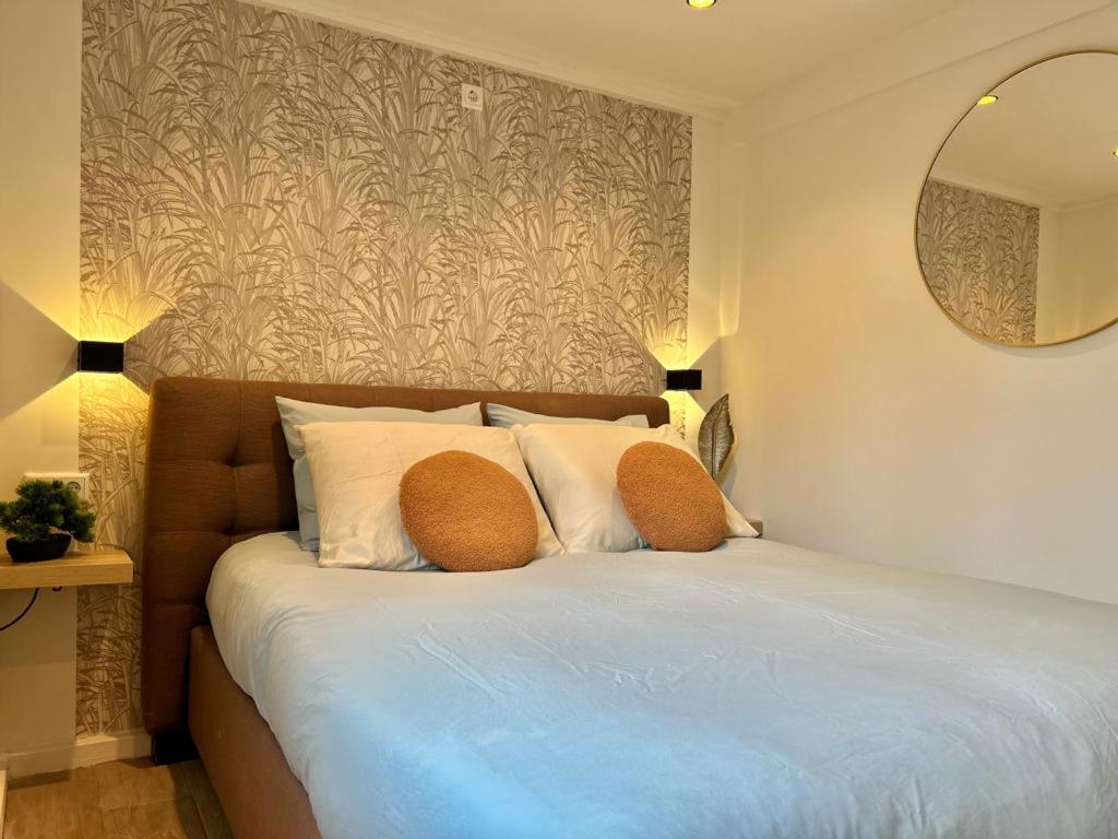 sypialnia z łóżkiem z 2 poduszkami i lustrem w obiekcie Lovely tiny house w Zandvoort