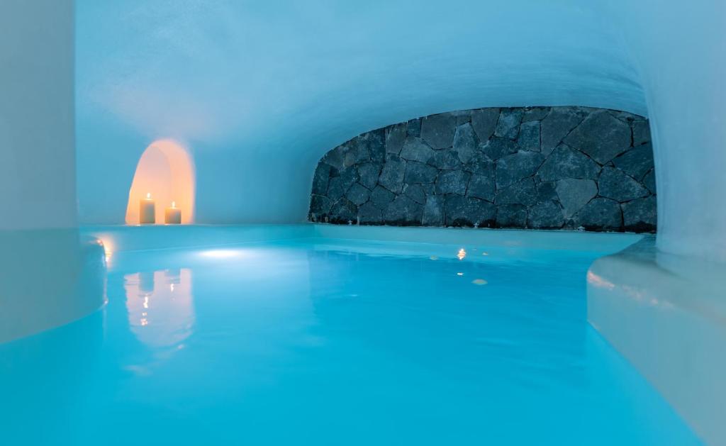 a blue room with candles in the water at Blue Cave Oasis with Underground Jacuzzi in Megalochori