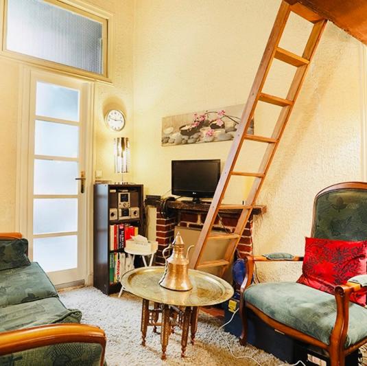 a living room with a ladder and a table and chairs at Lovely studio next to Notre-Dame in Paris