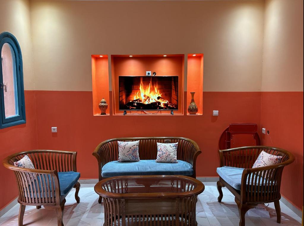 sala de estar con 2 sillas y chimenea en Spacious 3-Floor Riad en Marrakech