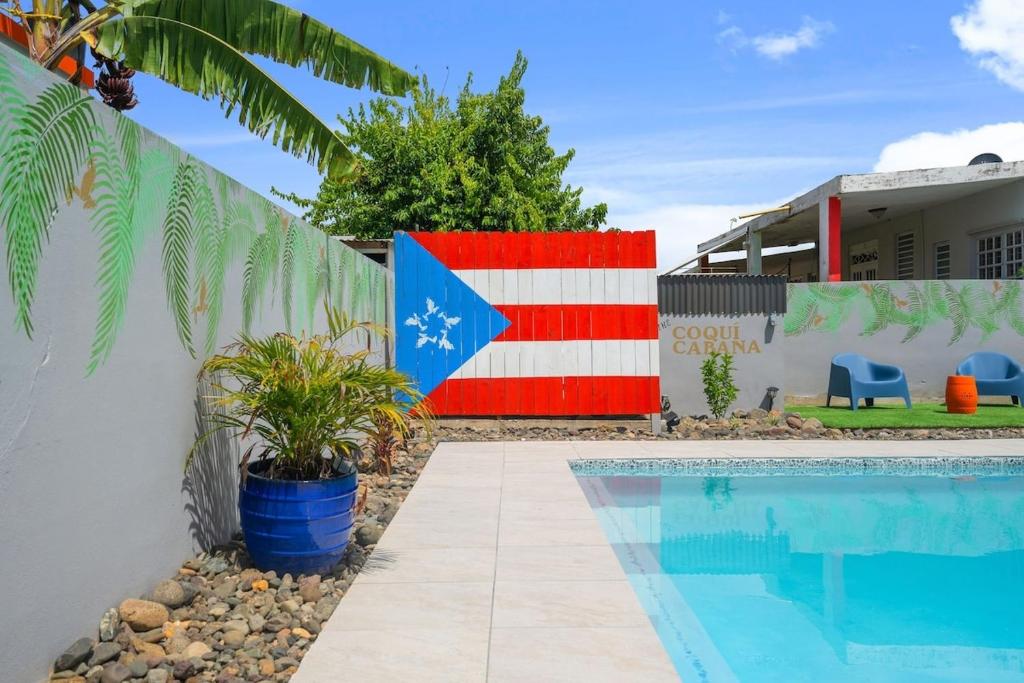un drapeau peint sur un mur à côté d'une piscine dans l'établissement walk to beach or swim in the pool, 4 bedrooms home, à Humacao