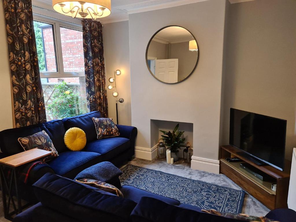 a living room with a blue couch and a mirror at Love Lane Villa in Lincoln