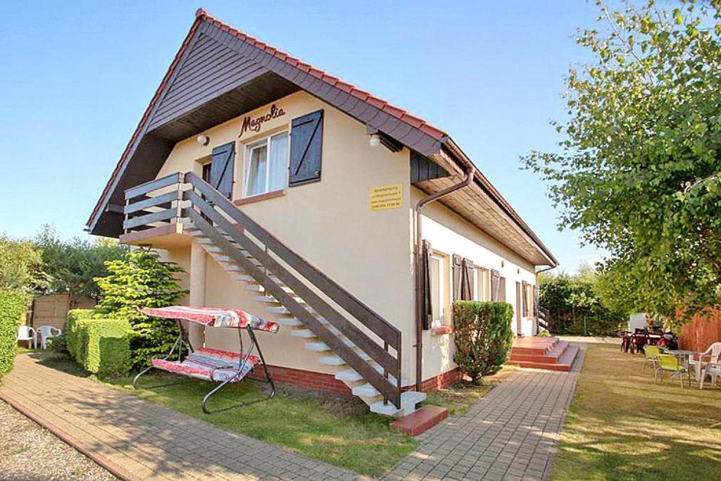 a small house with stairs on the side of it at Apartment in Rowy with a garden in Rowy