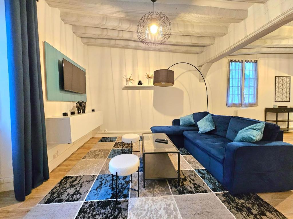 a living room with a blue couch and a table at Grand appart 6 pers Cœur de Nemours in Nemours
