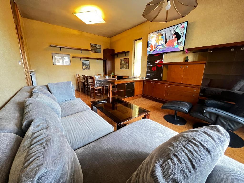 uma sala de estar com dois sofás e uma televisão em Villa Gianfranca - sentiti come a casa em Corno di Rosazzo