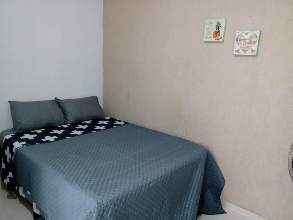 Schlafzimmer mit einem Bett mit blauer Decke in der Unterkunft ParkFlat in Sorocaba
