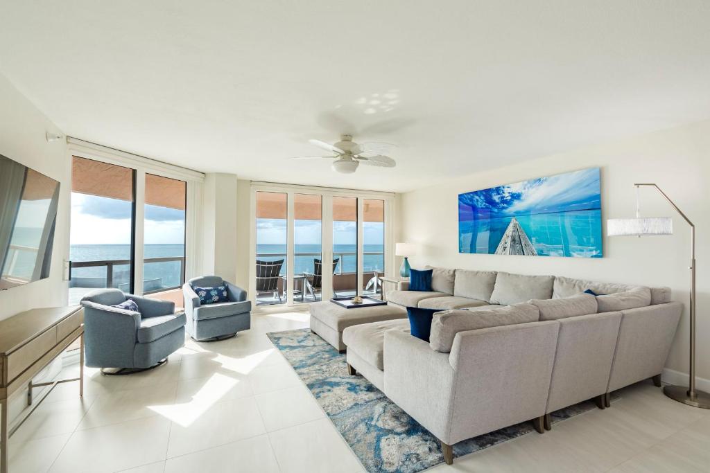 uma sala de estar com um sofá e uma mesa em Steps to Beach & Pool - Resort Amenities Galore! em Clearwater Beach