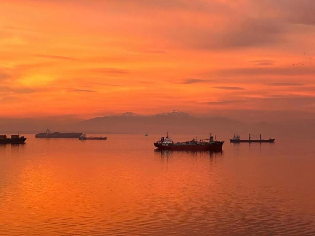 um grupo de barcos na água ao pôr do sol em ICONIC SALONICA SUITE seafront em Tessalônica