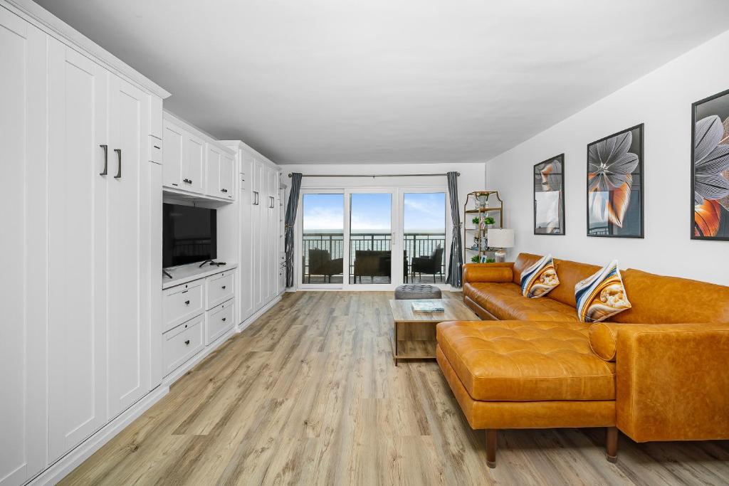 a living room with a couch and a tv at Oceanfront Jewel - Remodeled to Perfection in Rehoboth Beach