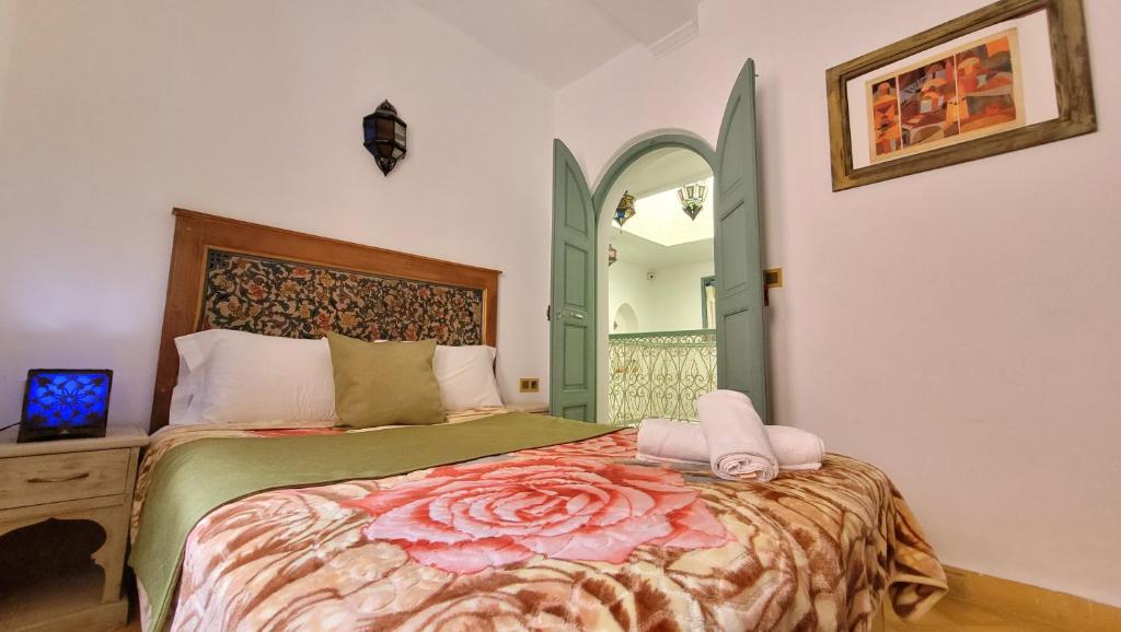 a bedroom with a bed with a floral bedspread at Honey Suckle in Chefchaouene
