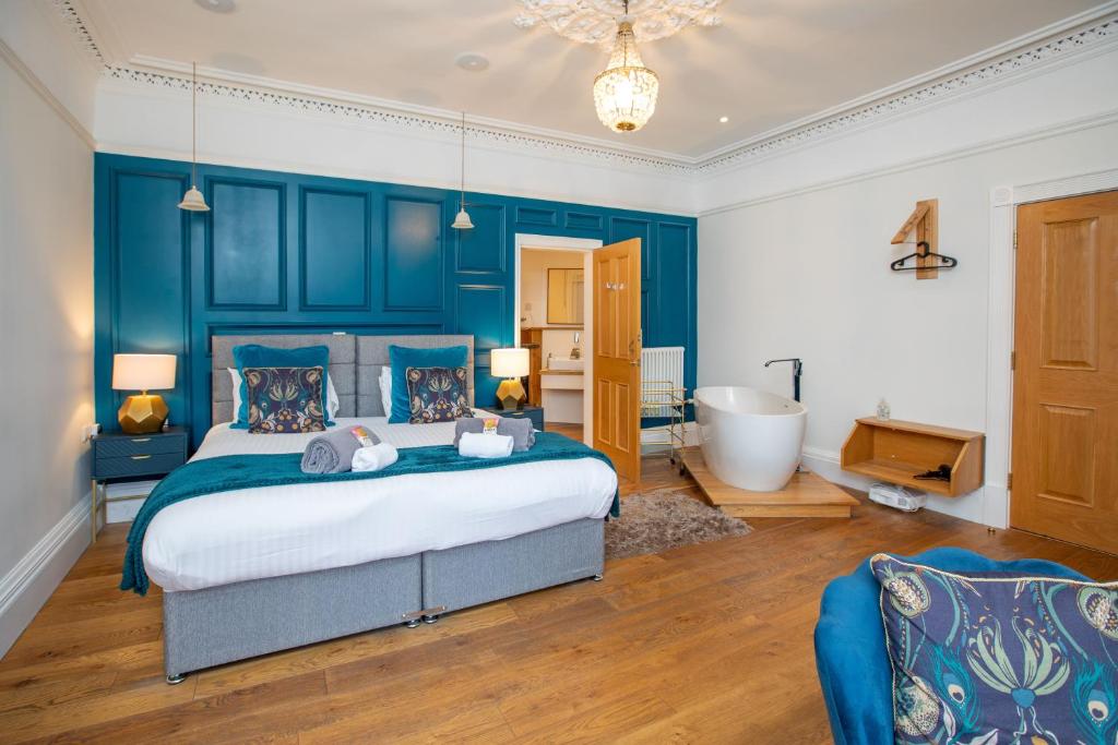 a bedroom with a large bed and a bath tub at The Fig Tree Markinch, Glenrothes in Markinch