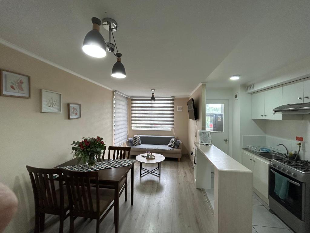eine Küche und ein Wohnzimmer mit einem Tisch und einem Sofa in der Unterkunft Departamento nuevo con perfecta ubicación in Osorno