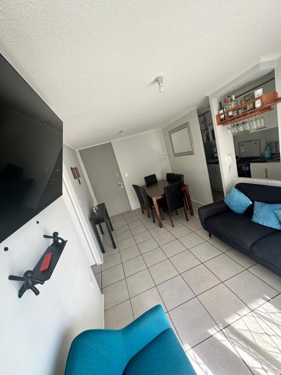 ein Wohnzimmer mit einem blauen Sofa und einem Tisch in der Unterkunft Frente a aeropuerto in La Serena