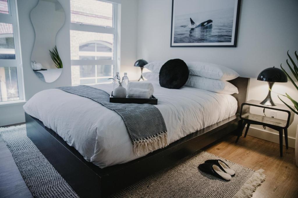 een slaapkamer met een bed met witte lakens en kussens bij The Orca Pad at Waddigton Flats in Victoria